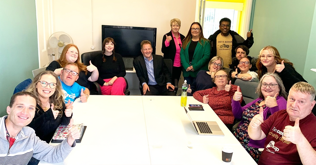 Photograph of Easy Read Employees and Liverpool Menace Group sat around a table.